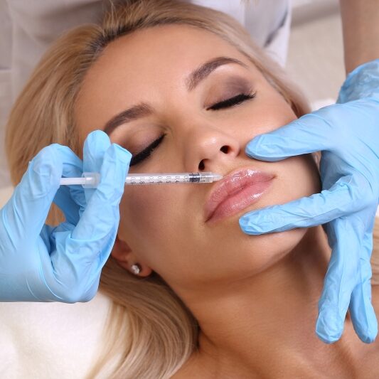 relaxed woman receiving lip filler injection